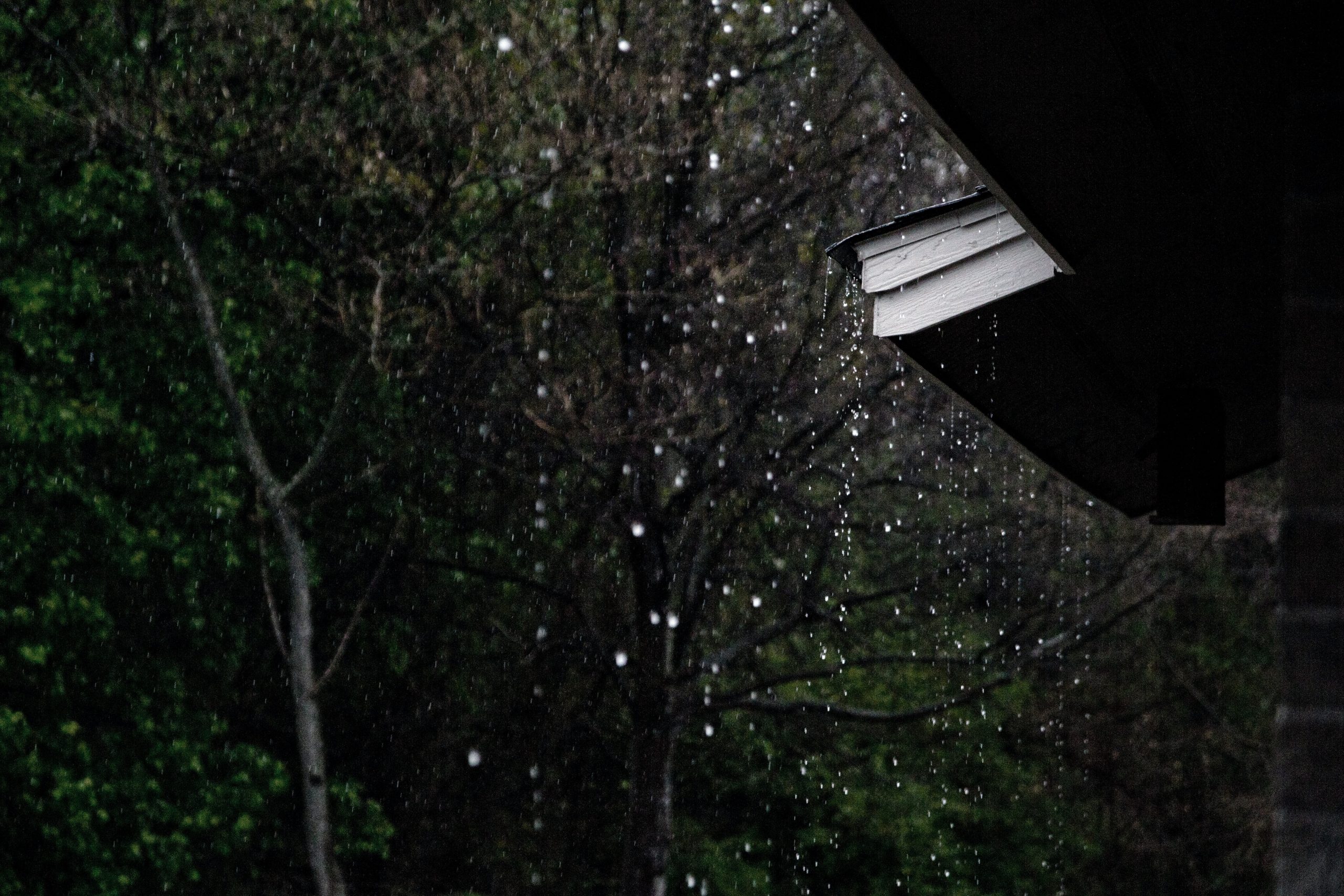 Water raining heavily on roof of house